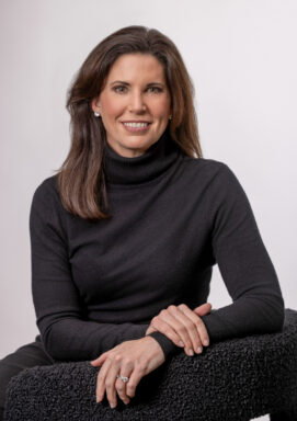 Studio portrait of taken in Fayetteville, Ark. Branding portrait of a woman in a black turtleneck seated in a studio, photographed in Fayetteville, Arkansas by Beth Hall Photography.
